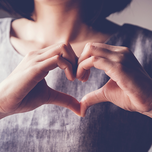 Social Work A person shaping their hands into a love heart