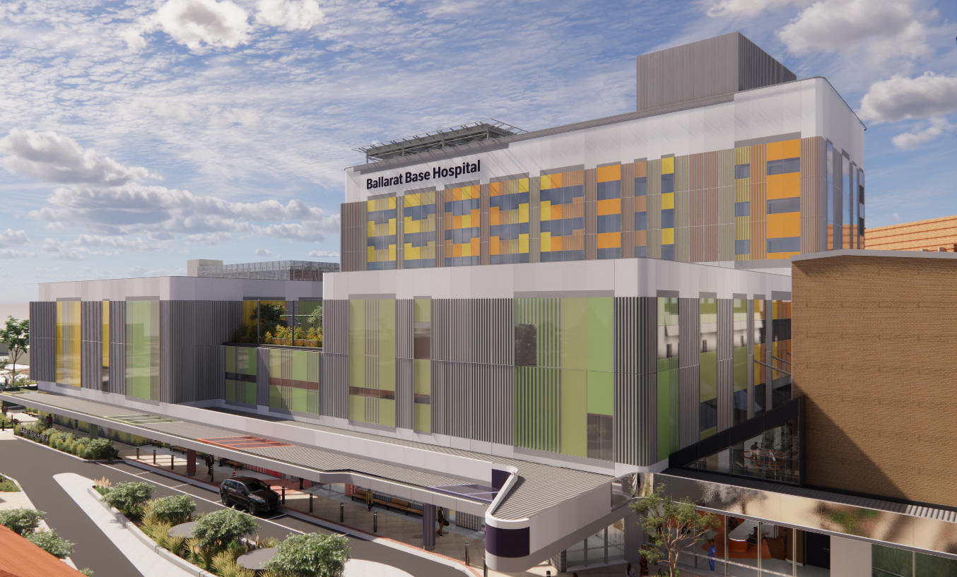 South Eastern View Of The Main Works Tower, Emergency And Main Entrance Drop Off And Community Courtyard Cropped Ve Copy Modern hospital building labeled "Ballarat Base Hospital" featuring glass and metal panels with green and orange accents. Multi-level structure includes a drive-up entrance area. Partly cloudy sky enhances the bright, clean appearance.