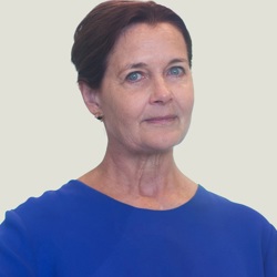 Heather Pickard 53045041568 O A person with short, dark hair wearing a blue top and the background is plain and light-colored.